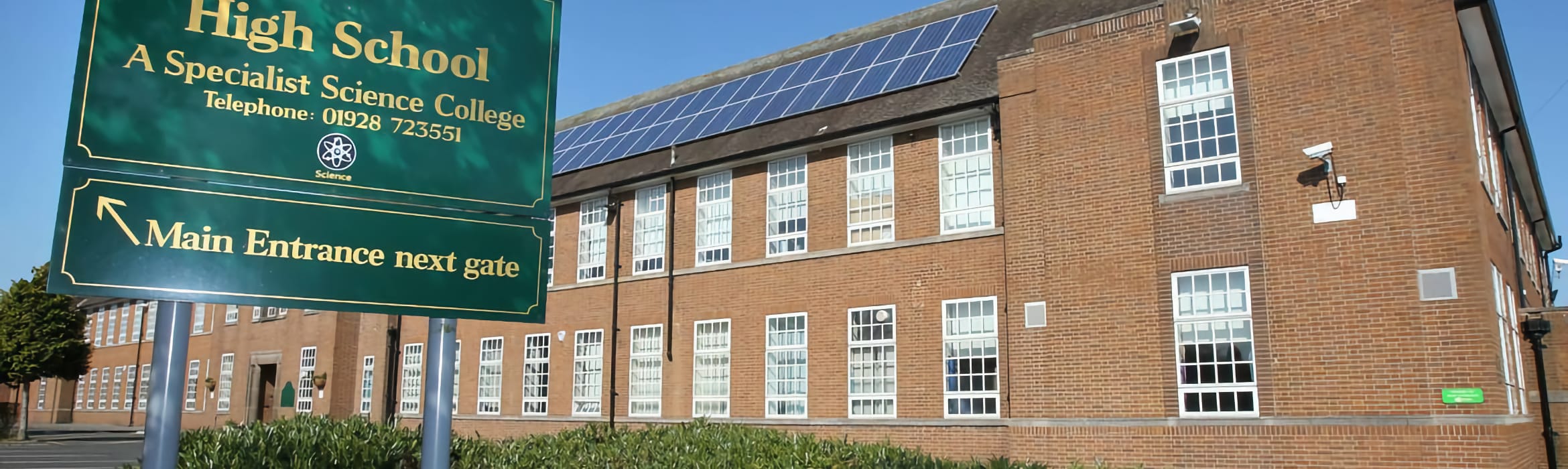 Helsby High School sign and logo with the school building in the background