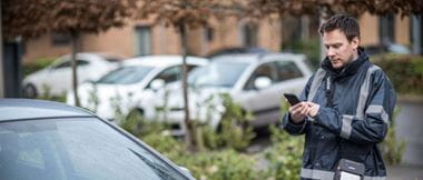 Een mannelijke parkeerwachter print een parkeerboete met mobiele printer van Brother