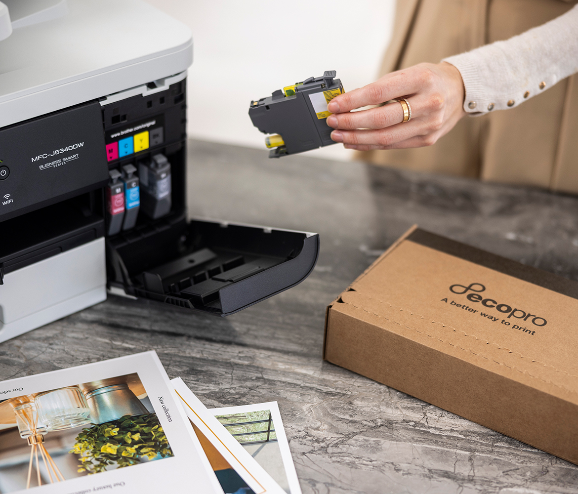 Woman replacing printer cartridge on printer with a brown box on the table