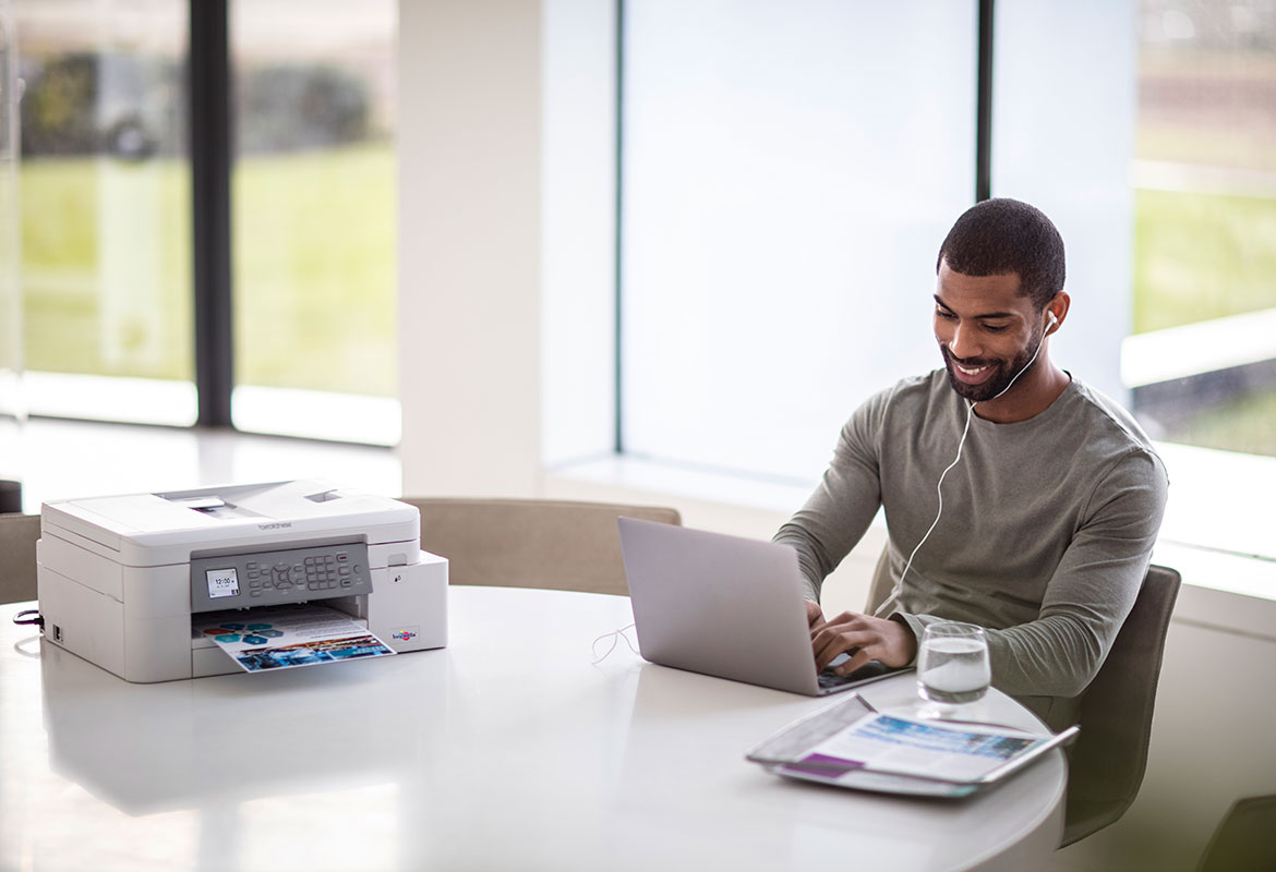 Een man aan het werk naast een Brother wifi printer