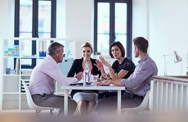 Four business people sitting around a table