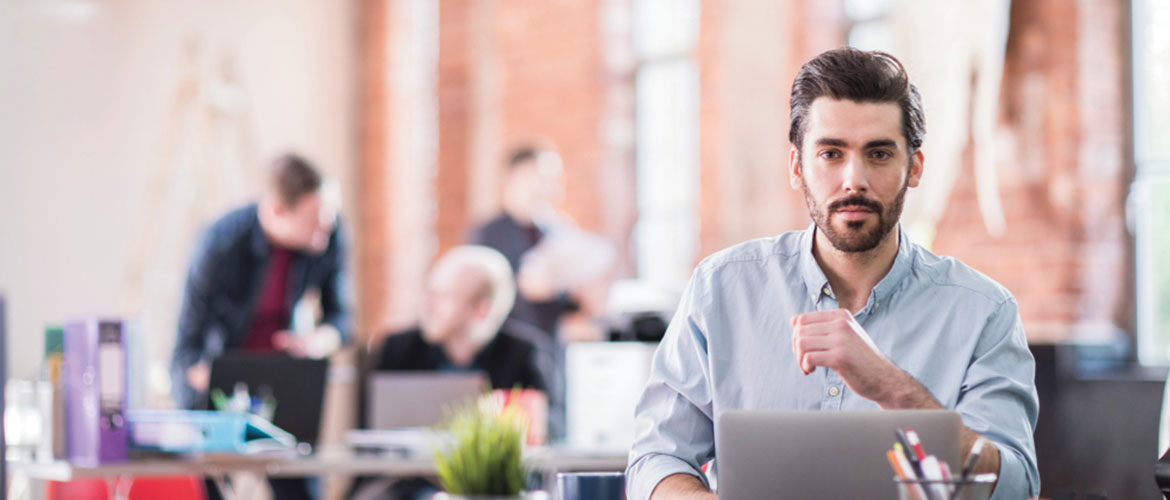 Man sat at a desk on a laptop 