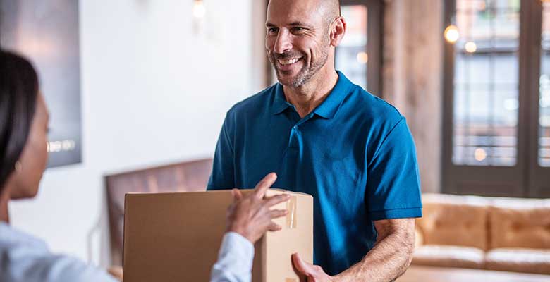 Man delivering package to woman in office reception