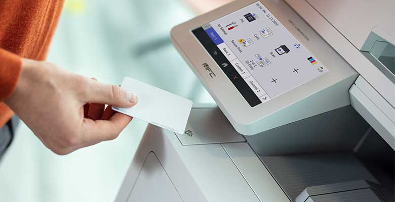 Person holding NFC card next to printer with screen