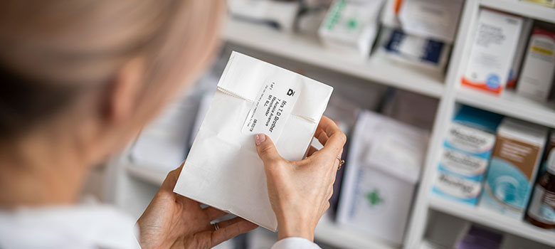Application d'une étiquette sur un sac de médicaments dans une pharmacie