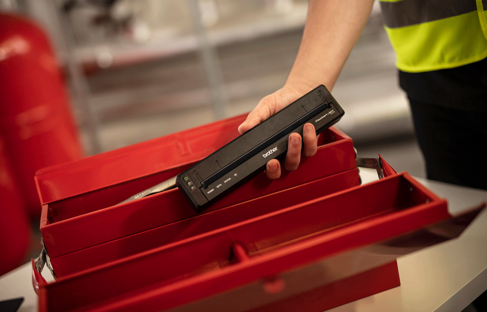 Workman putting black pj printer in red worbox