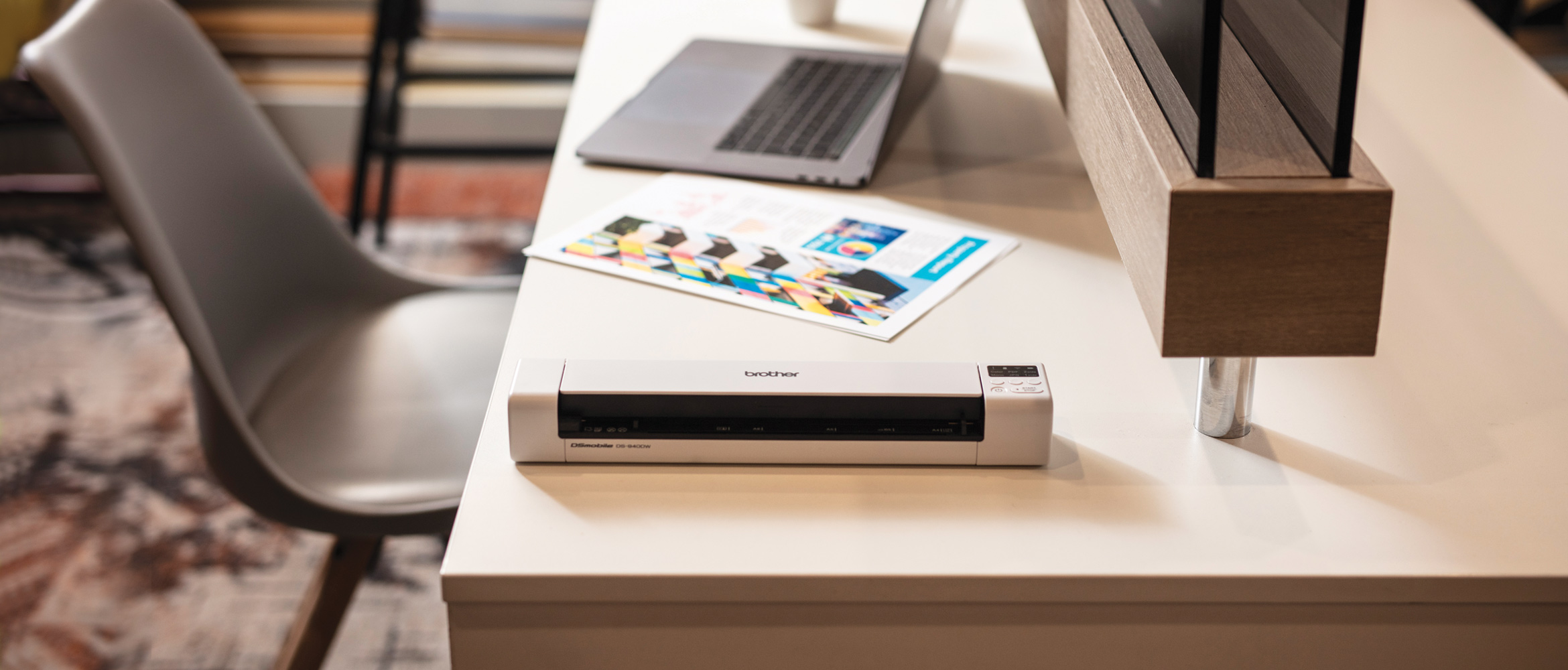 Scaner mobil DS-940DW pe birou, un document color A4, scaun gri