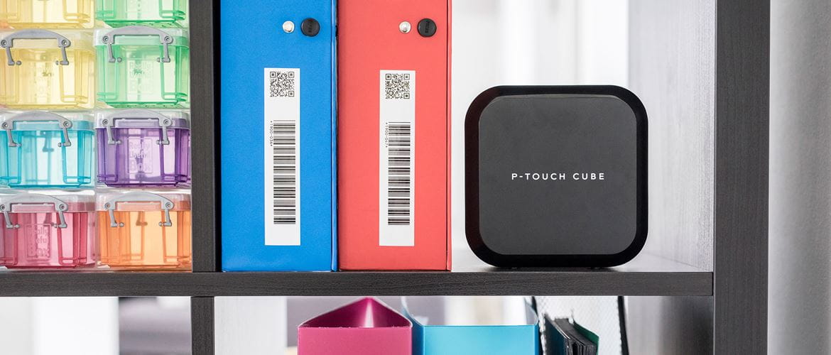 Brother P-touch label printer on a shelf next to labelled file folders with barcodes