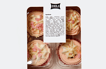 Rózsaszín és fehér cupcake-ek fehér és átlátszó műanyag dobozban, összetevő címkével