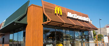 Stavba McDonaldsa z modrim nebom in logotipom pred stavbo 