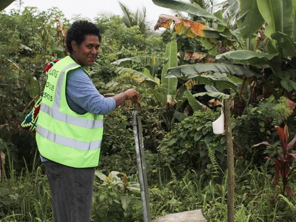 Zaměstnanec RWSSP během výzkumné návštěvy ve vesnicích v Milne Bay pomáhá projektům Cool Earth, které Brother podporoval.