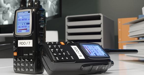 Dva radio walkie-talkie uređaja s identifikacijskim naljepnicama koje su izrađene na Brother P-touch pisaču naljepnica