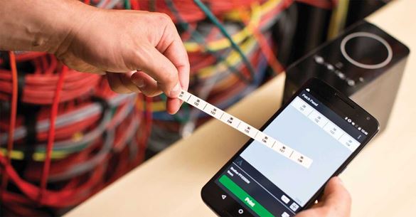 Aplicația Cable label tool pe un smartphone cu o etichetă imprimată Brother P-touch