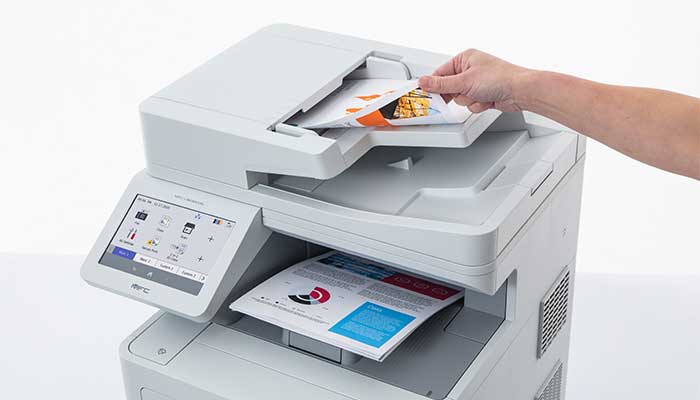 Prim-plan al documentului color în ADF al imprimantei cu documentul ținut în mână