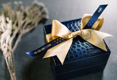 O cutie cadou albastră și o panglică cu fundă aurie