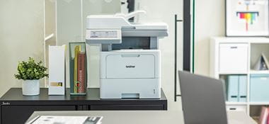 Multifunkční laserová tiskárna Brother MFC-L6910DN na polici v kancelářském prostředí