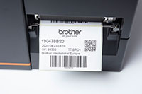Close up of Brother TJ industrial label printer printing barcode labels