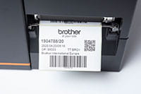 Близък план на индустриален етикетен принтер Brother TJ, отпечатващ етикети с баркод