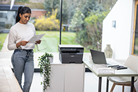Woman holding mono output next to printer