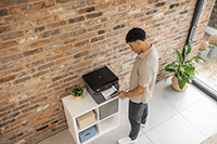 Man taking mono output from printer in home environment