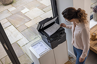 Woman taking mono output from flatbed of Brother printer