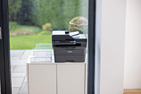 Brother printer on top of cabinet in home office environment