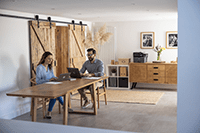 Couple sat working in home environment