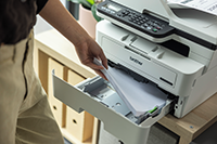 MFCB7810DW in a home office with the paper input tray being filled