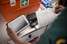 Pracownik służby zdrowia drukuje przy pomocy drukarki przenośnej z serii PJ 700 i tableta