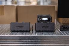 Dva PACR005 nosača/punjača za baterije s 1 postajom na polici u skladištu, s jednim mobilnim pisačem RJ-3200 koji se puni 