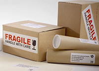 Etykiety wysyłkowe i etykiety informujące o tym, że produkt jest delikatny przyklejone do brązowych pudełek