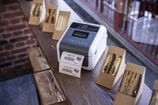 Етикетен принтер TD-4D отпечатва етикет за залепване върху кутии за сандвичи в магазин за деликатеси