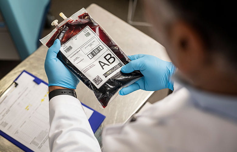 Doctor ținând o pungă de sânge etichetată
