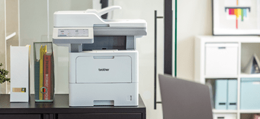 Brother MFC-L6915DN multifunction laser printer on top of a cabinet in an office environment