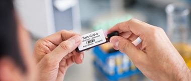 Medizinische Fachkraft Beschriftet eine Sonde mit Klebe-Etikett aus EtikettendRucker.