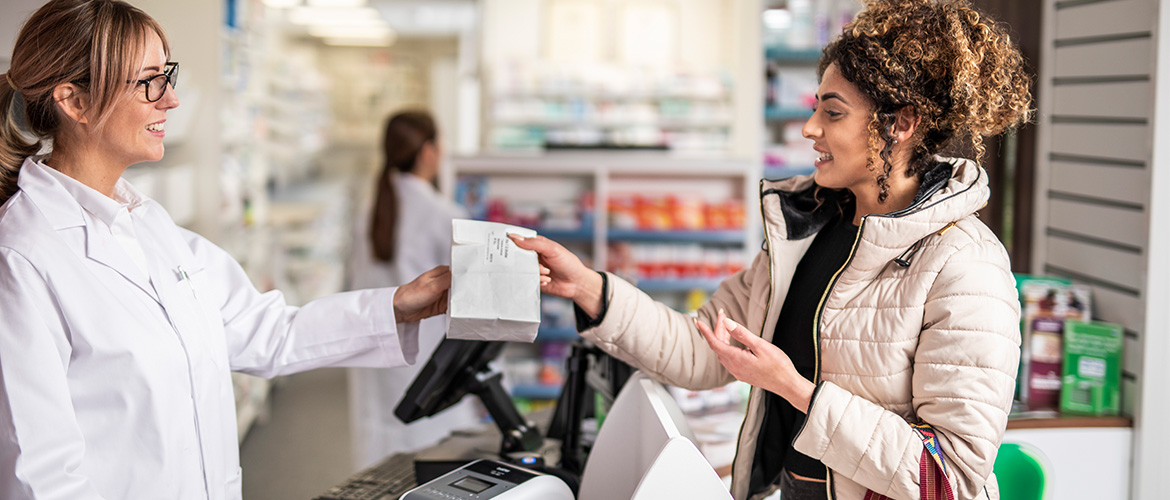 Apothekerin ÜbergiBT Einer Kundin Ein TÜTE mit Medikamente.