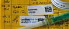 Impfpass mit Etikett von Coronaschutzimpfen, Spritzen und Ampulle.