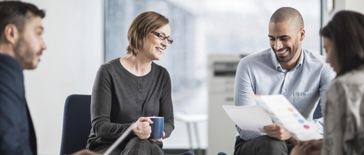 Vier Menschen sitzen im Büro BUMO Brainstorming.