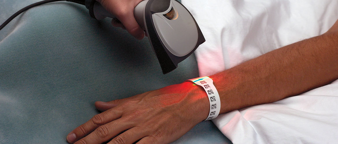 Scanner scannt Barcode auf Patientenarmband