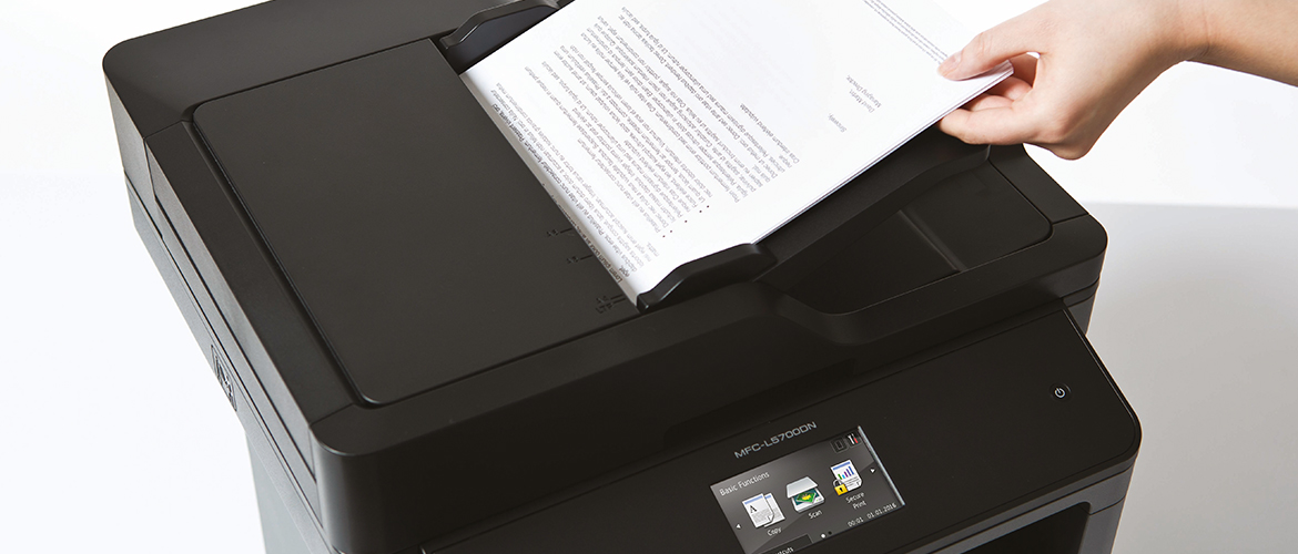 Eine Hand legt ein Papierdokument zum Scannen in den automatischen Vorlageneinzug eines Multifunktionsdruckers von Brother. 