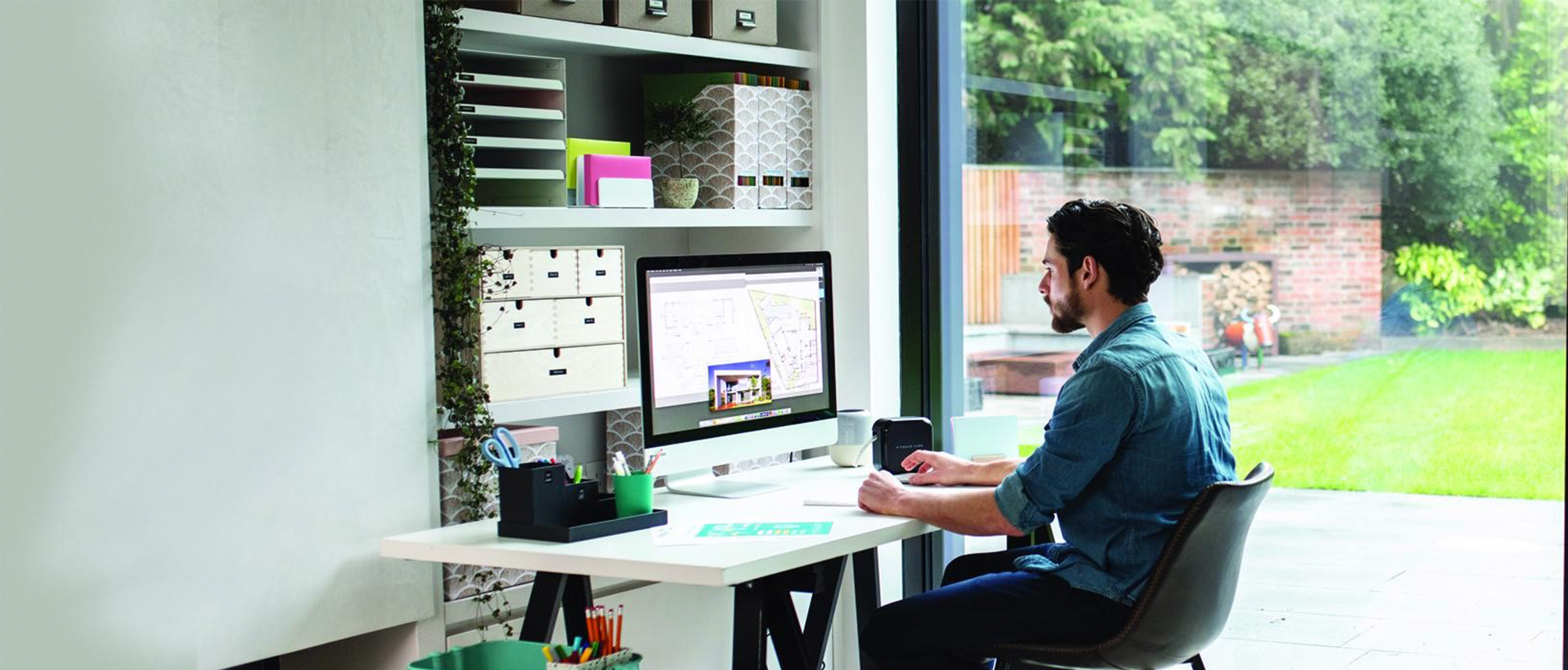 Mann sitzend am Schreibtisch im Home Hoffice