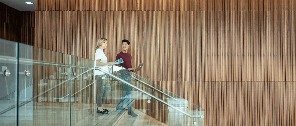 A man and woman walking down stairs talking