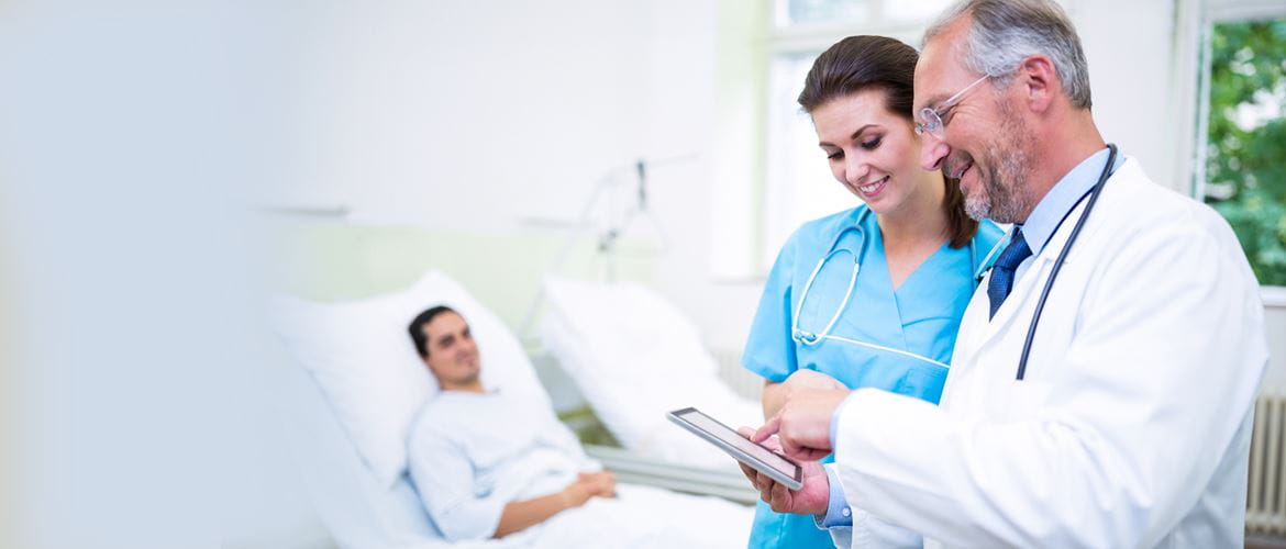Arzt mit Krankenschwester im Gespräch, auf Patientenakte schauend, Patient im Hintergrund
