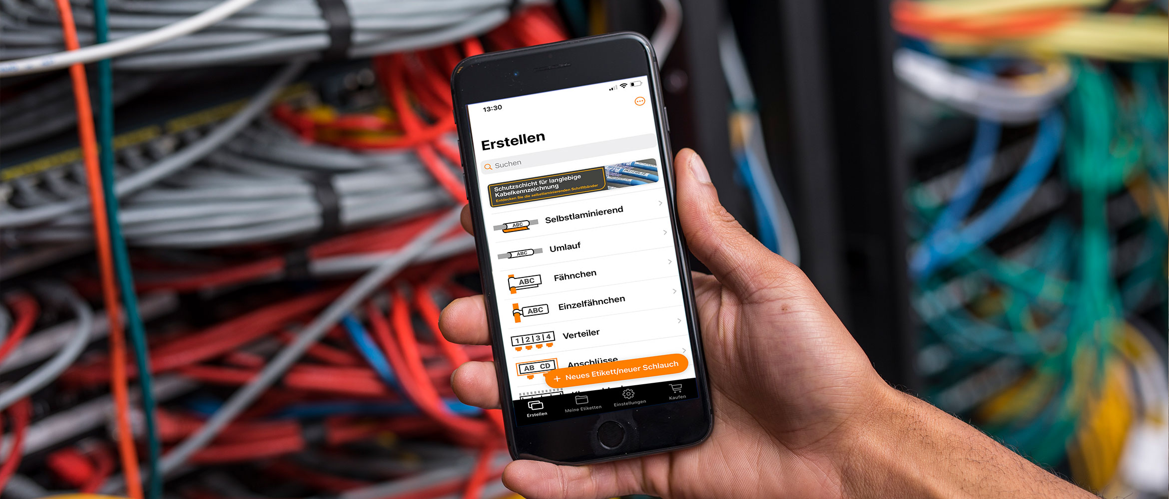 Eine Person zeigt die Pro Label Tool App in Nahansicht. Kabel im Hintergrund.