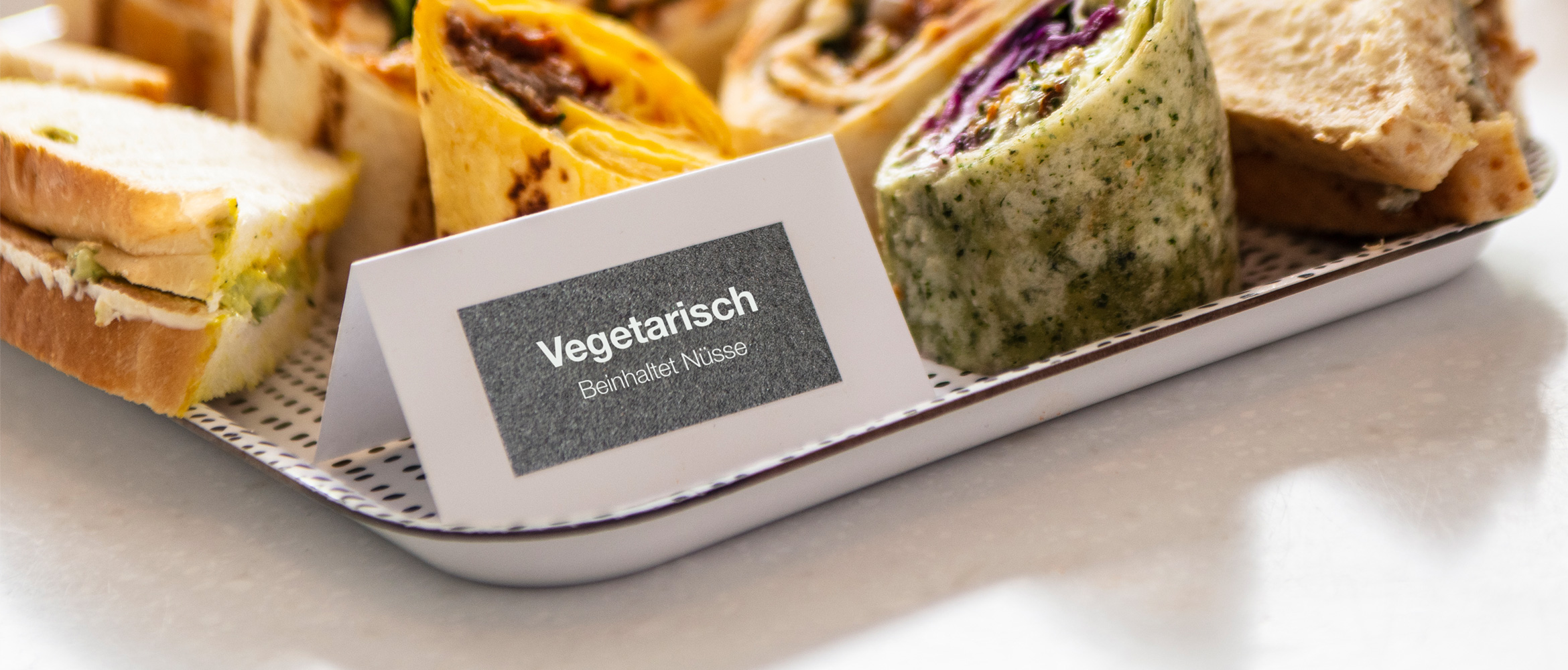 Weißes Buffetschild mit Brother Silber-GlitzernDem TZE-SCHRIFTBAND BEDRUCKT AUF Tablet mit verschendenen Canapes