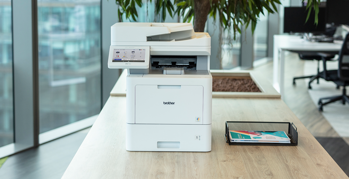 Brother Laserdrucker steht auf einem Tisch, Pflanze im Hintergrund