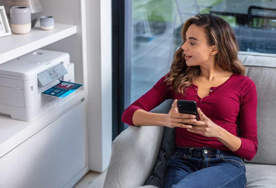 Ein-Frau-Hut ein Apple-iPhone in der Hand und Druckt über Einen Airprint-Drucker etwas AUS.