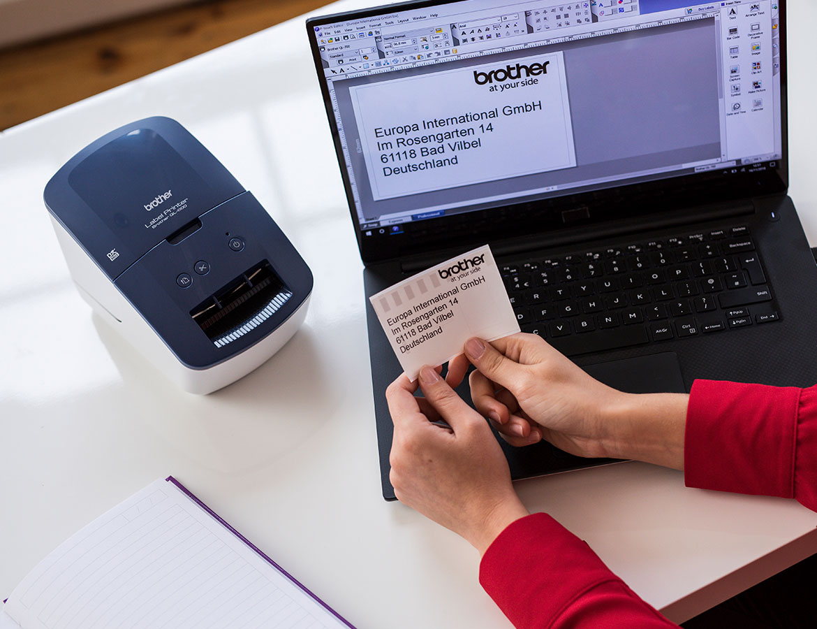 Eine Person hält ein Etikett in der Hand, das von einem Thermodrucker von Brother gedruckt wurde