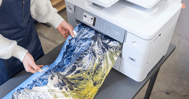 Großformatiges Papier einer Landschaft auf Glanzpapier, das aus dem Drucker gedruckt wird