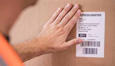 Logistik-mitarbeiter klebt Brother etikett ein paket